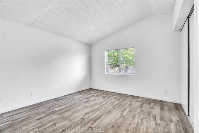 15696 Paine St, Fontana, CA 92336 - unfurnished room featuring a textured ceiling, wood finished floors, vaulted ceiling, and baseboards