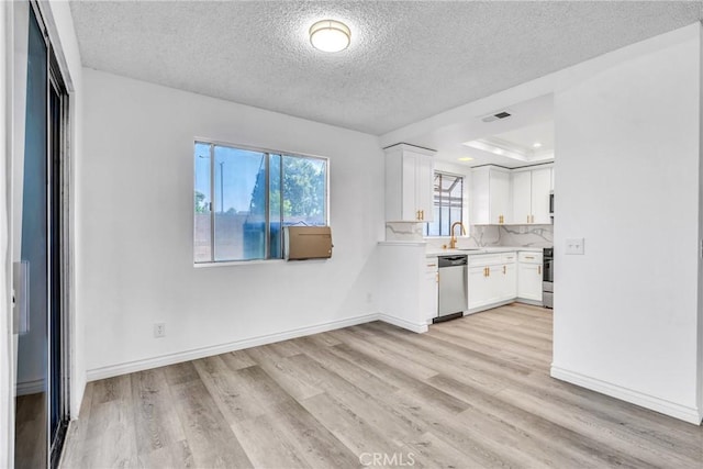15696 Paine St, Fontana, CA 92336 - kitchen featuring stainless steel dishwasher, a textured ceiling, white cabinets, light countertops, and light wood finished floors