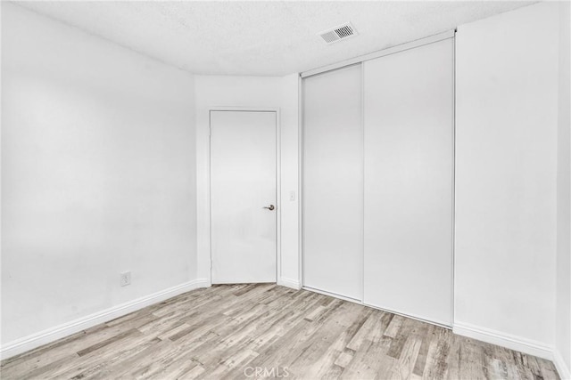 15696 Paine St, Fontana, CA 92336 - unfurnished bedroom with light wood-style floors, a closet, a textured ceiling, and baseboards