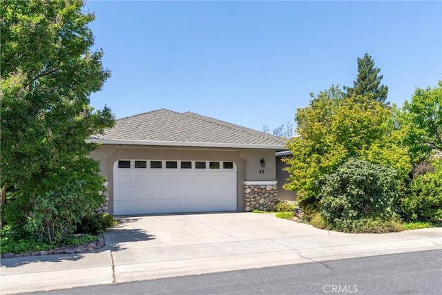 43 Edgewater Ct, Chico, CA 95928 - view of front of property with stucco siding, concrete driveway, an attached garage, and stone siding