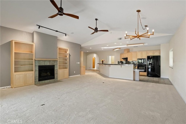 43 Edgewater Ct, Chico, CA 95928 - unfurnished living room featuring ceiling fan, lofted ceiling, arched walkways, light carpet, and a tiled fireplace
