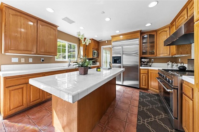 1036 Alpine Ct, Chino Hills, CA 91709 - kitchen featuring high quality appliances, extractor fan, recessed lighting, brown cabinetry, and a kitchen island