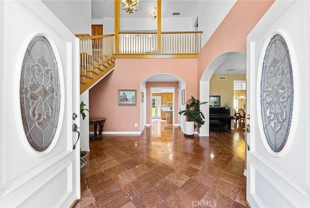 1036 Alpine Ct, Chino Hills, CA 91709 - entryway featuring stairway, a towering ceiling, baseboards, arched walkways, and a chandelier