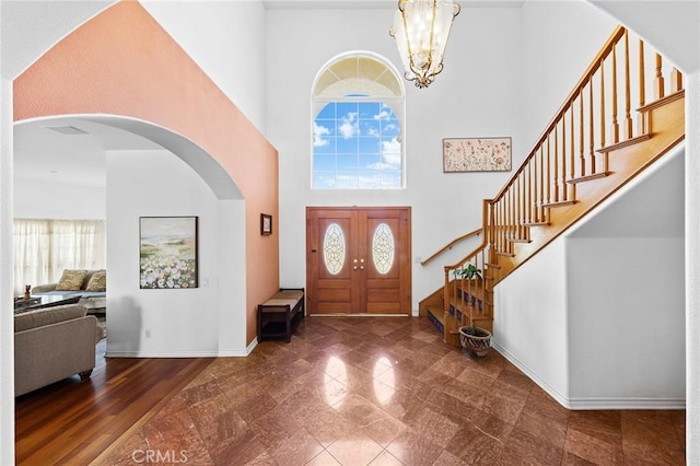 1036 Alpine Ct, Chino Hills, CA 91709 - foyer entrance featuring stairs, a towering ceiling, arched walkways, baseboards, and a chandelier