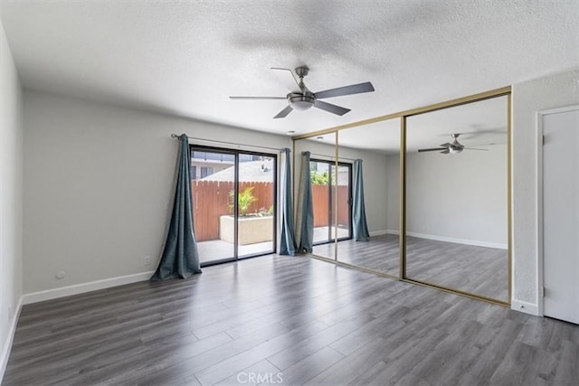 unfurnished bedroom featuring access to exterior, wood finished floors, a textured ceiling, baseboards, and ceiling fan