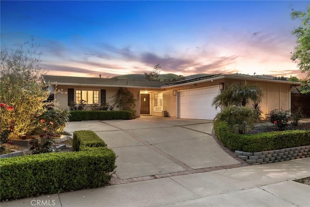 5839 Parkmor Rd, Calabasas, CA 91302 - ranch-style house featuring a garage, concrete driveway, roof mounted solar panels, and stucco siding
