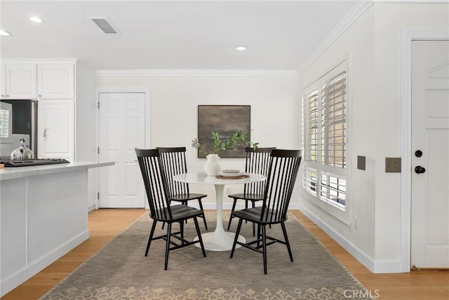 5839 Parkmor Rd, Calabasas, CA 91302 - dining area with crown molding, light wood-style floors, recessed lighting, and baseboards