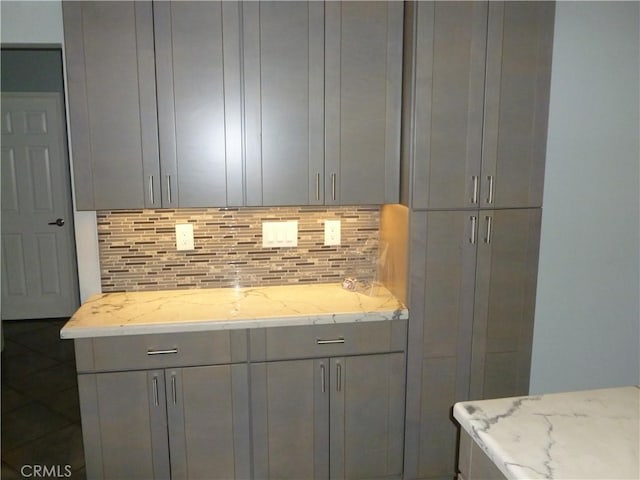 26223 Crestone Dr, Menifee, CA 92586 - kitchen featuring gray cabinets, tasteful backsplash, and light stone counters