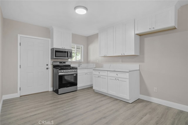 4875 Fairway Blvd, Chino Hills, CA 91709 - kitchen with appliances with stainless steel finishes, light wood-style floors, baseboards, white cabinets, and a sink