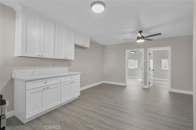4875 Fairway Blvd, Chino Hills, CA 91709 - kitchen with a ceiling fan, baseboards, and white cabinetry