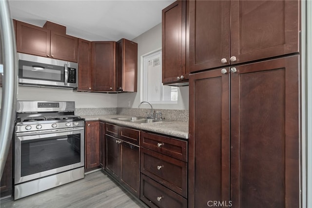 4875 Fairway Blvd, Chino Hills, CA 91709 - kitchen with stainless steel appliances, a sink, light wood-style flooring, and light countertops