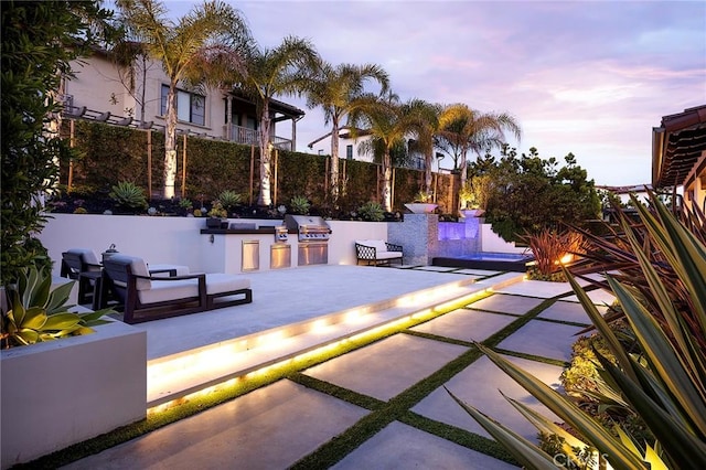 135 Via Artemesia, San Clemente, CA 92672 - patio terrace at dusk featuring an outdoor kitchen, a grill, fence, and a swimming pool