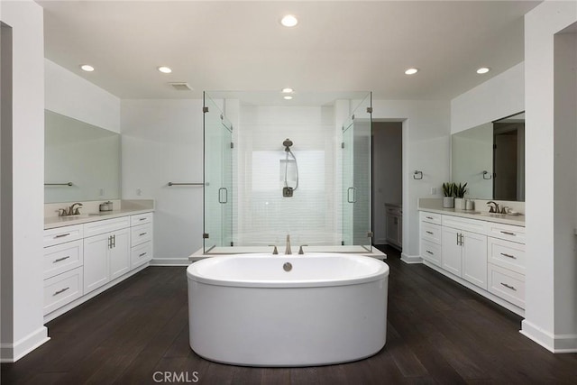 135 Via Artemesia, San Clemente, CA 92672 - bathroom with two vanities, a stall shower, wood finished floors, a freestanding tub, and recessed lighting