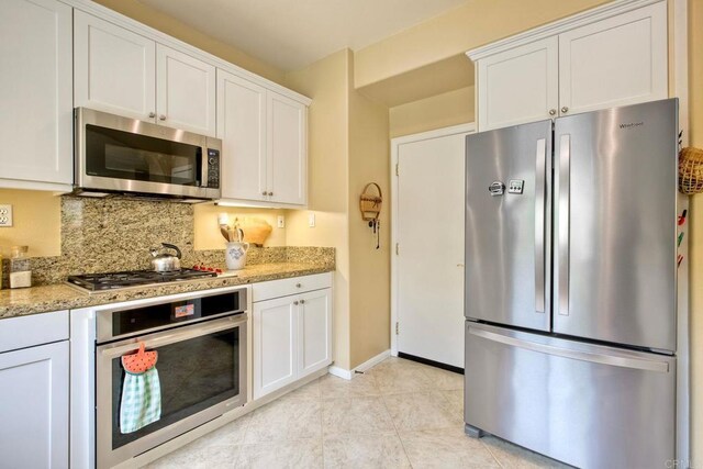 11590 Trailbrook Ln, San Diego, CA 92128 - kitchen featuring stainless steel appliances, backsplash, white cabinets, and light stone counters