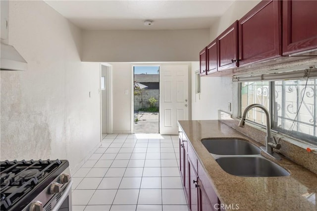 1550 E Sandison St, Wilmington, CA 90744 - kitchen featuring dark brown cabinets, a sink, gas range, stone countertops, and light tile patterned flooring