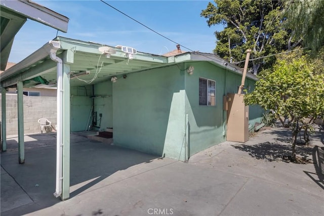1550 E Sandison St, Wilmington, CA 90744 - view of side of home featuring stucco siding and an attached carport