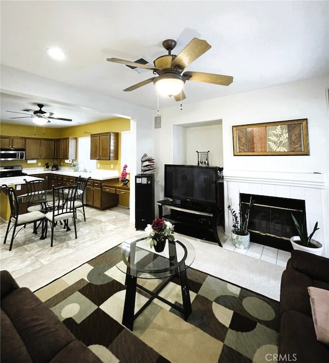 13217 Acacia Ave, Moreno Valley, CA 92553 - living area featuring a ceiling fan, a tiled fireplace, recessed lighting, and light tile patterned flooring