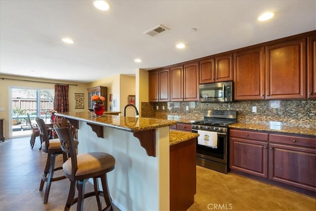 287 Tom Mcguinness Jr Cir, Fallbrook, CA 92028 - kitchen with stainless steel appliances, a kitchen bar, backsplash, stone counters, and light tile patterned floors