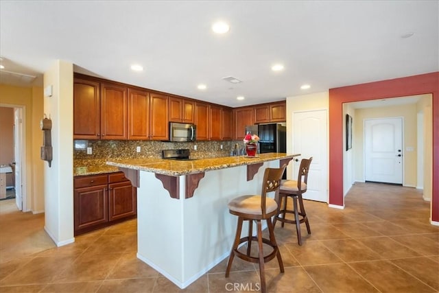 287 Tom Mcguinness Jr Cir, Fallbrook, CA 92028 - kitchen featuring stainless steel microwave, a kitchen breakfast bar, tasteful backsplash, light tile patterned floors, and recessed lighting