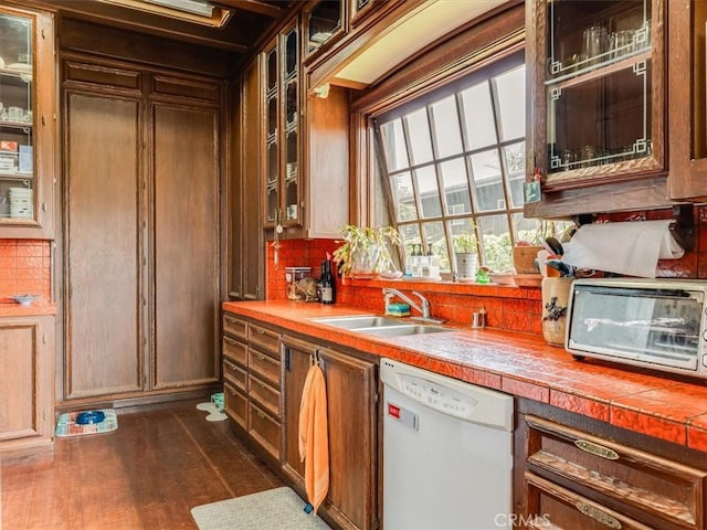 6570 Moonstone Beach Dr, Cambria, CA 93428 - kitchen featuring dishwasher, a sink, dark wood finished floors, and glass insert cabinets