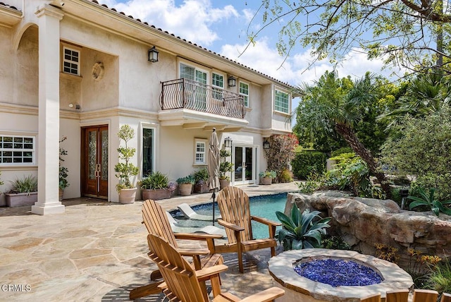 15450 Briarwood Dr, Sherman Oaks, CA 91403 - rear view of house featuring french doors, a balcony, an outdoor fire pit, a patio area, and an outdoor pool