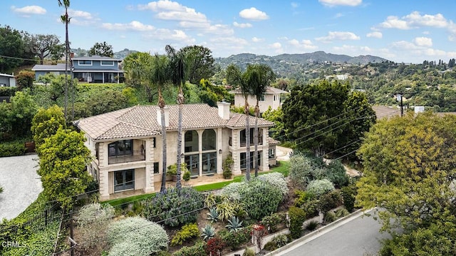 15450 Briarwood Dr, Sherman Oaks, CA 91403 - view of front of property featuring a tiled roof, a balcony, stucco siding, a chimney, and a mountain view