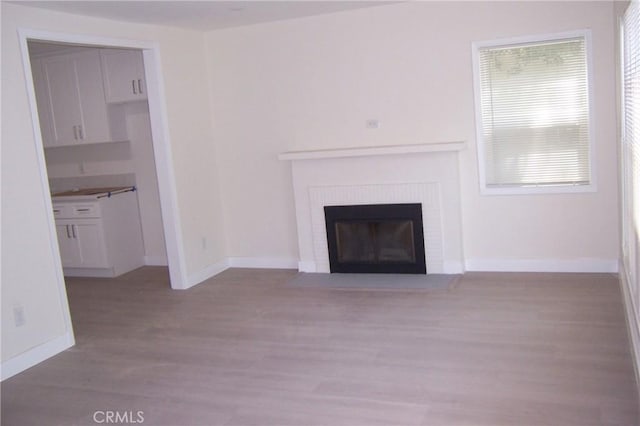 3069 N F St, San Bernardino, CA 92405 - unfurnished living room with wood finished floors, a fireplace, and baseboards