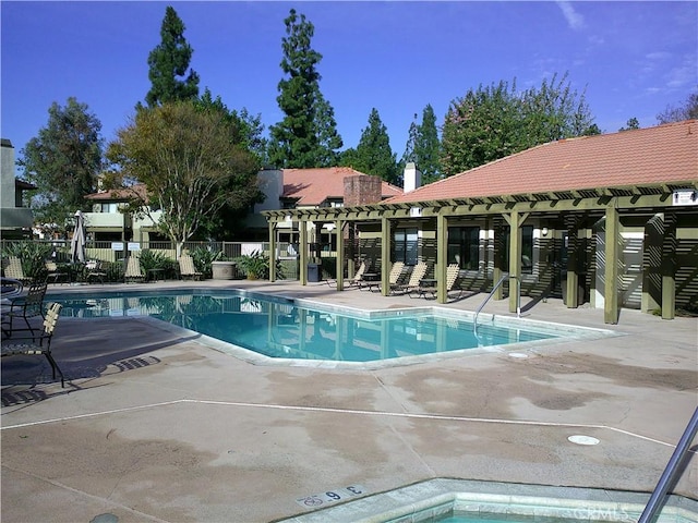 community pool with a pergola, a patio area, and fence