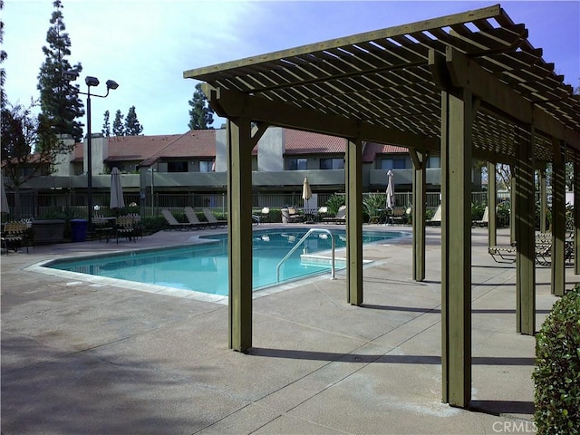 community pool featuring a patio area, fence, and a pergola