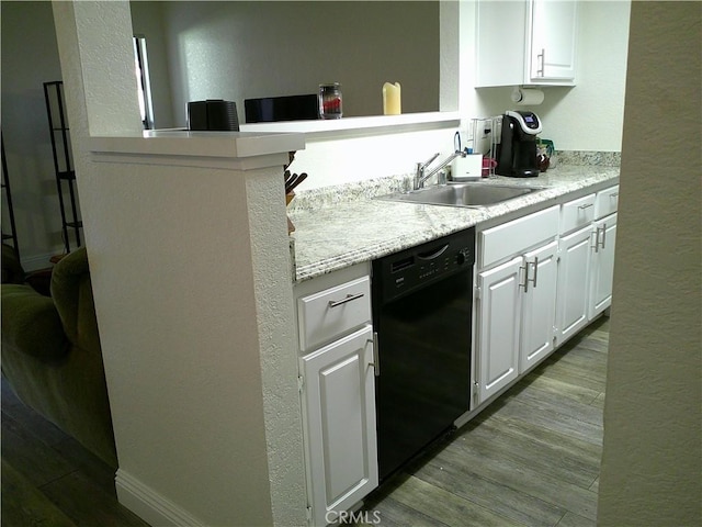 kitchen featuring dishwasher, a sink, light countertops, white cabinets, and a textured wall