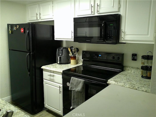 kitchen featuring black appliances and white cabinetry
