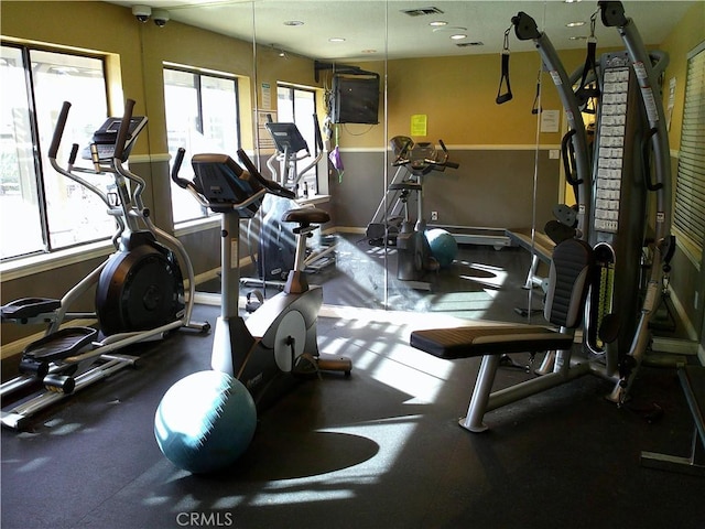 exercise room with healthy amount of natural light and baseboards