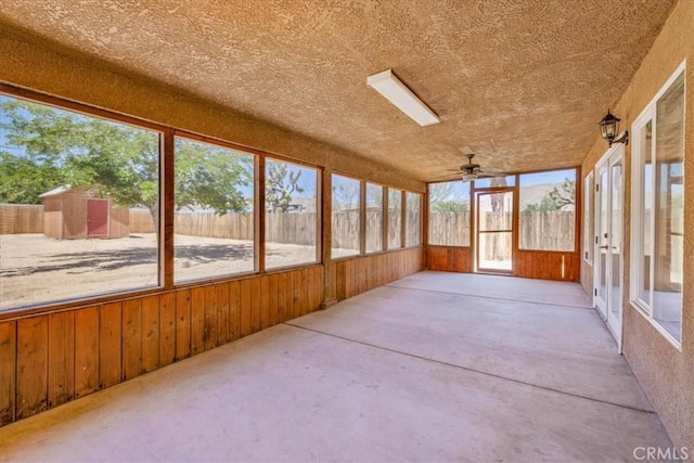 7566 Fox Trl, Yucca Valley, CA 92284 - unfurnished sunroom featuring wood walls, ceiling fan, and concrete floors