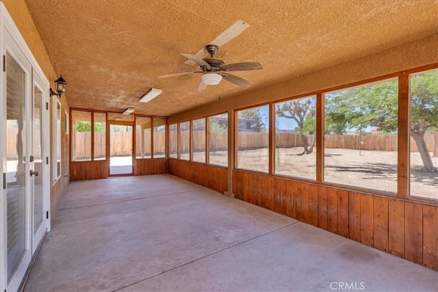 7566 Fox Trl, Yucca Valley, CA 92284 - unfurnished sunroom with wooden walls, ceiling fan, healthy amount of natural light, french doors, and a textured ceiling