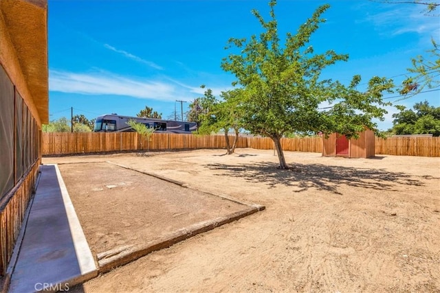 7566 Fox Trl, Yucca Valley, CA 92284 - fenced backyard featuring a storage unit and an outbuilding