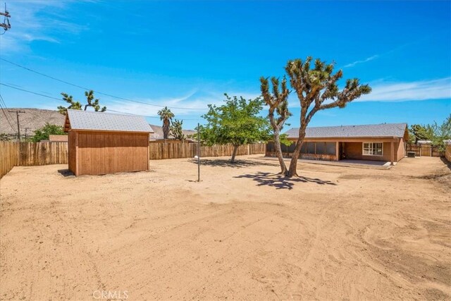 7566 Fox Trl, Yucca Valley, CA 92284 - fenced backyard featuring a storage shed and an outdoor structure
