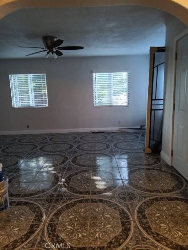 2506 E 130th St, Compton, CA 90222 - empty room with baseboards, ceiling fan, and arched walkways