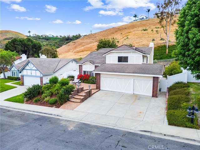 28705 Charreadas, Laguna Niguel, CA 92677 - view of front of property featuring an attached garage, driveway, a mountain view, a tiled roof, and stucco siding
