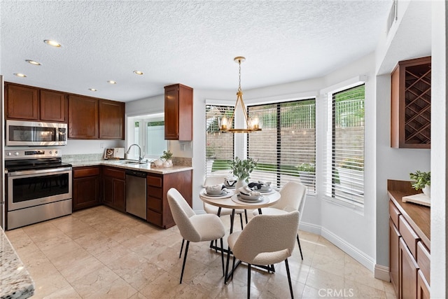 28705 Charreadas, Laguna Niguel, CA 92677 - kitchen with appliances with stainless steel finishes, baseboards, a sink, a chandelier, and a textured ceiling