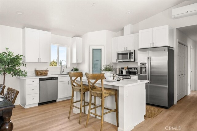 6333 Graham Rd, Paradise, CA 95969 - kitchen featuring stainless steel appliances, a wall mounted AC, light wood finished floors, a center island, and a sink