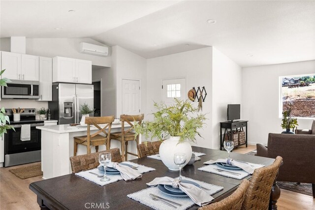 6333 Graham Rd, Paradise, CA 95969 - dining space featuring an AC wall unit, light wood finished floors, and lofted ceiling