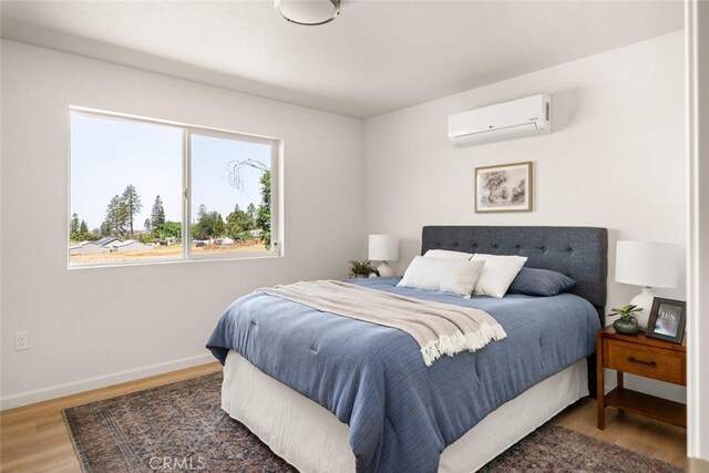 6333 Graham Rd, Paradise, CA 95969 - bedroom featuring a wall unit AC, wood finished floors, and baseboards