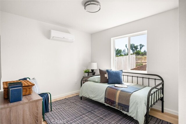6333 Graham Rd, Paradise, CA 95969 - bedroom with an AC wall unit, baseboards, and wood finished floors