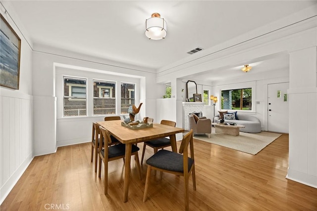 859 N Chester Ave, Pasadena, CA 91104 - dining space featuring light wood-type flooring, a fireplace, and a decorative wall