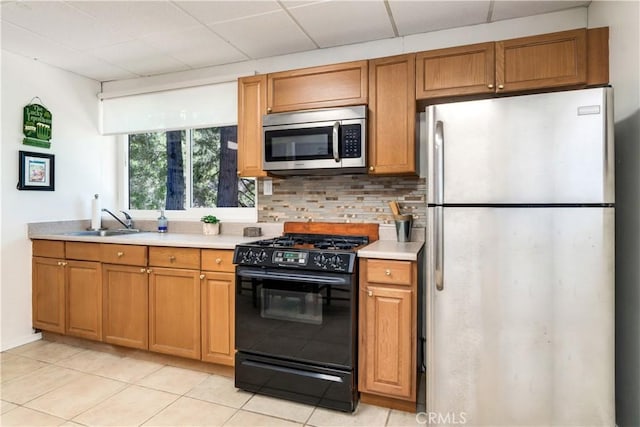6031 Tripp Ln, Angelus Oaks, CA 92305 - kitchen featuring appliances with stainless steel finishes, light countertops, a sink, and light tile patterned floors