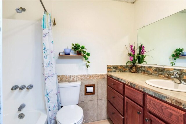 6031 Tripp Ln, Angelus Oaks, CA 92305 - bathroom featuring tile walls, vanity, toilet, shower / bath combination with curtain, and wainscoting