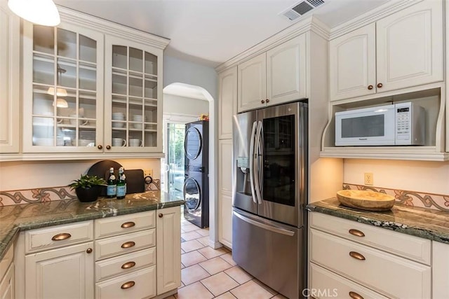 1443 Iris St, San Luis Obispo, CA 93401 - kitchen with stainless steel fridge, stacked washing machine and dryer, white microwave, arched walkways, and light tile patterned floors