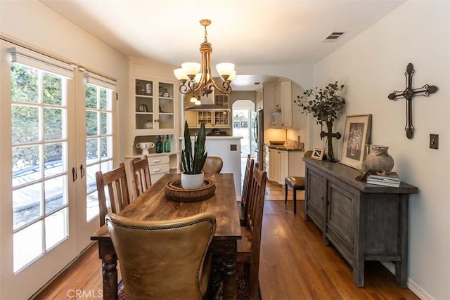 1443 Iris St, San Luis Obispo, CA 93401 - dining area featuring a chandelier, arched walkways, wood finished floors, and baseboards