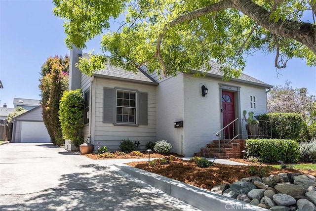 1443 Iris St, San Luis Obispo, CA 93401 - view of front facade with entry steps, an outdoor structure, a shingled roof, and a detached garage