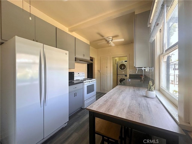551 W Walnut Ave, Monrovia, CA 91016 - kitchen featuring white appliances, stacked washer / drying machine, a sink, dark wood-style floors, and under cabinet range hood